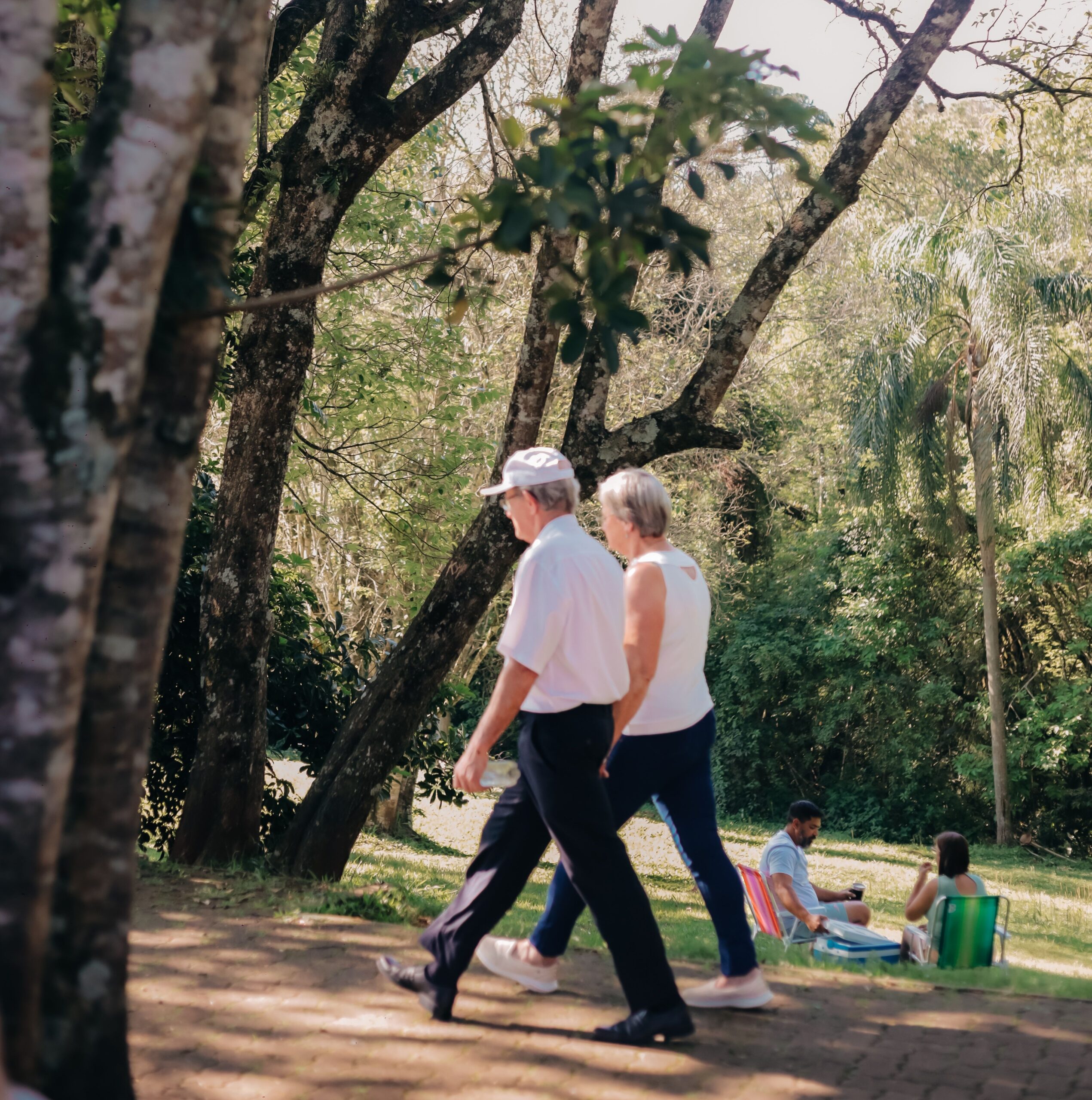 Dois residentes a passear num caminho arborizado ao ar livre