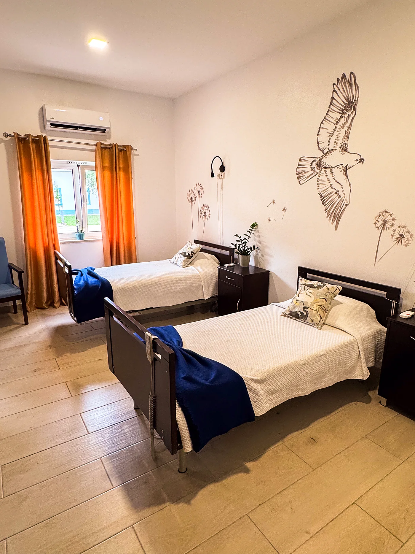 Quarto duplo com duas camas articuladas e luz natural numa residência CF Senior