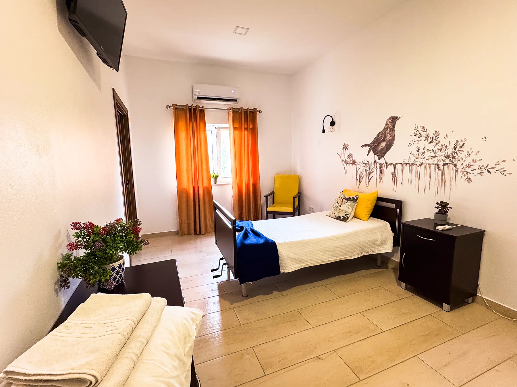 Quarto individual com cama articulada e televisão